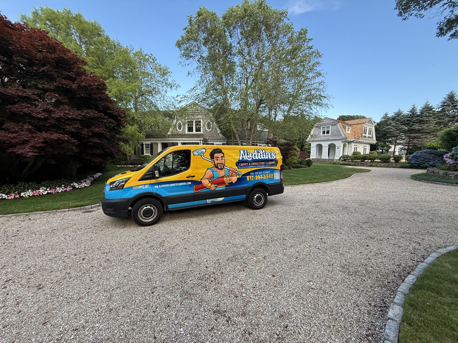 Aladdin’s van angled into a gravel driveway flanked by red maples